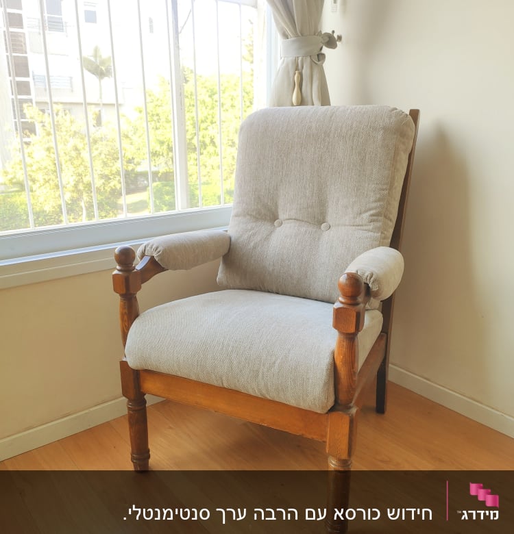 כורסה מרופדת בבד אפור עם מסגרת עץ